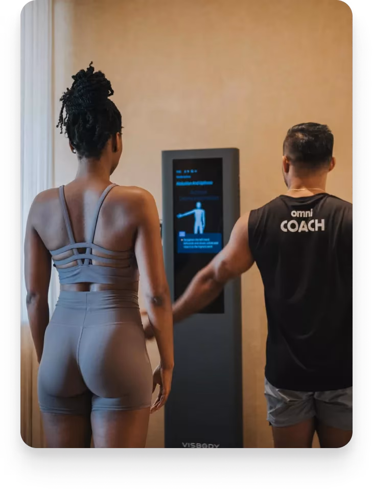 Coach begleitet einen Gast beim Scan am Visbody-Gerät