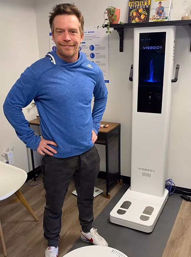 Sportler neben einem Visbody 3D-Körperscanner in einer Ernährungspraxis